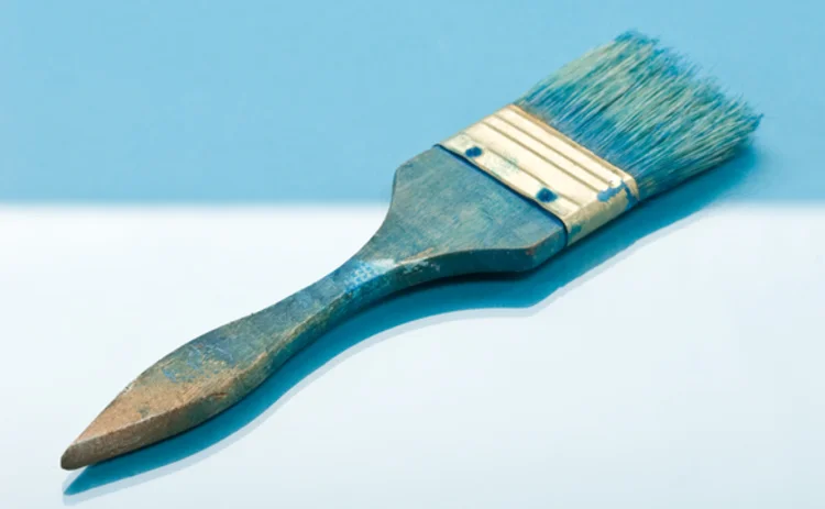 Blue paintbrush on two-tone blue background